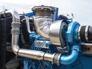 Boat motor fragment. Engine with turbocharger. Ship blue engine close-up. Fragment of ships engine with propeller. Concept of maintenance and repair of ship motors. Huge open air boat motor
